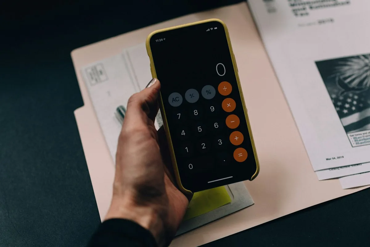Close view of office calculator confirming that total income minus expenses equals exactly zero
