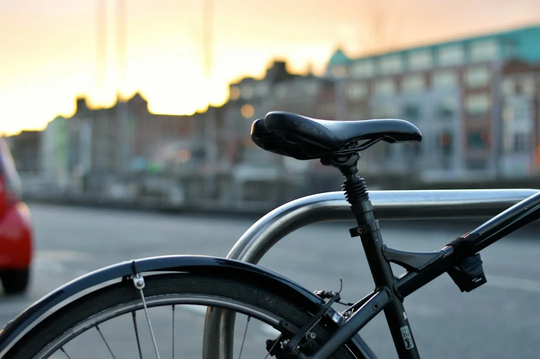 Classic commuter bicycle parked against brick wall on sunny quiet residential street