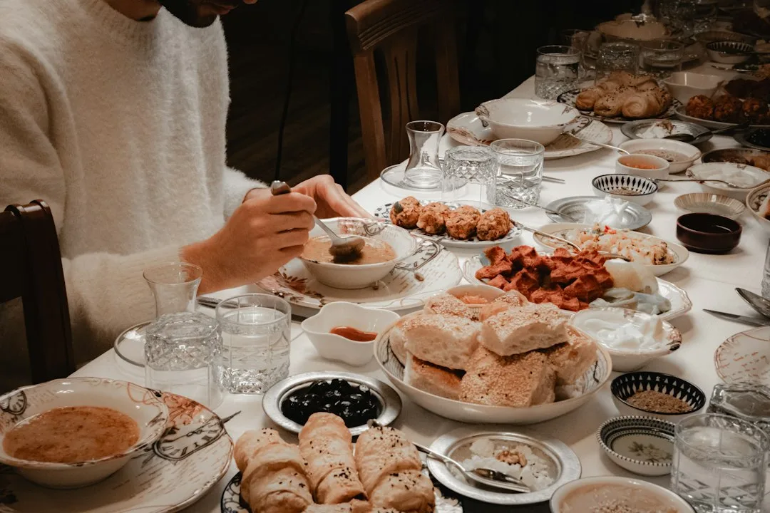 Smiling family sitting together around dining table sharing a warm home cooked dinner