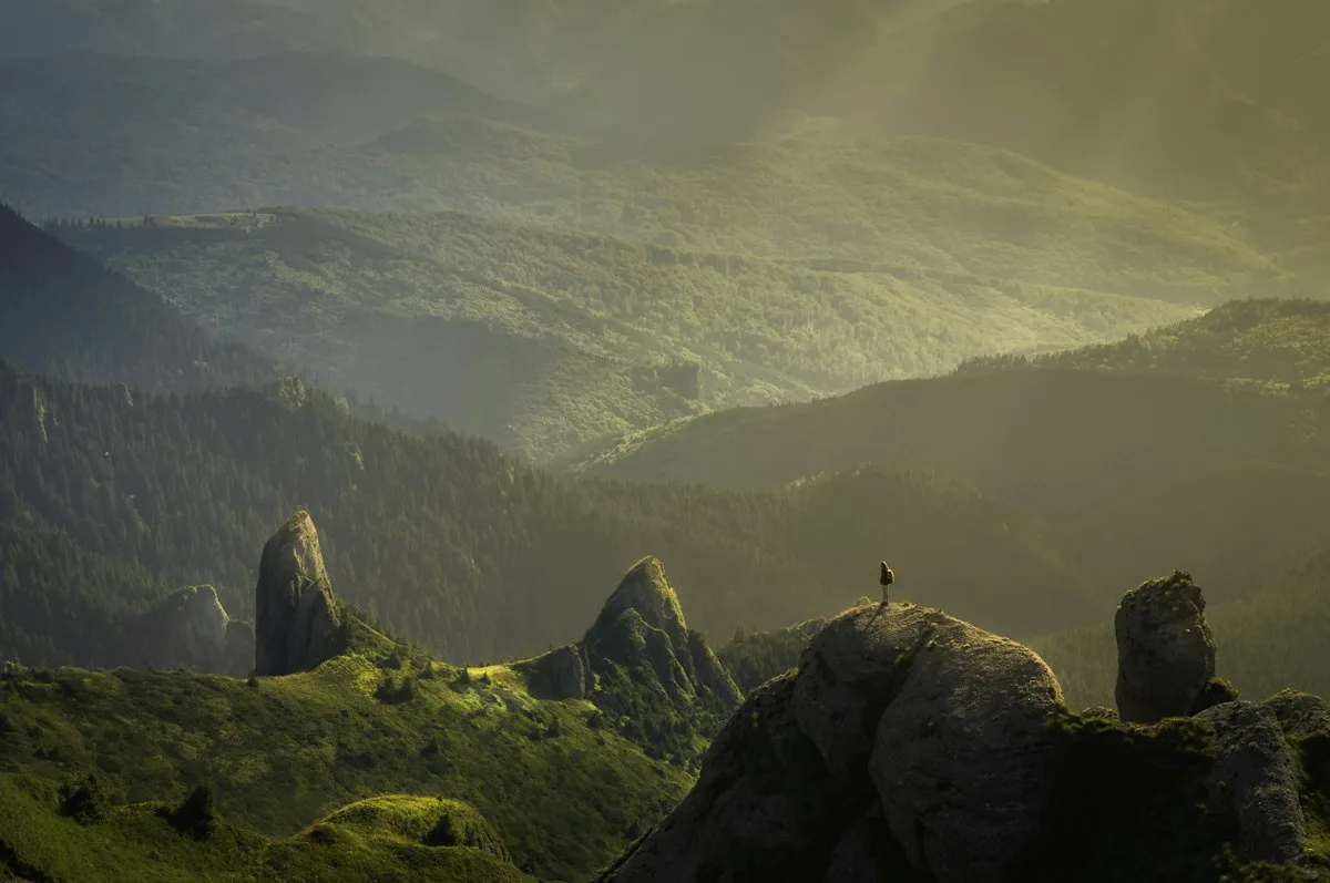 Scenic outdoor hiking trail leading through green mountains and forest in bright sunlight